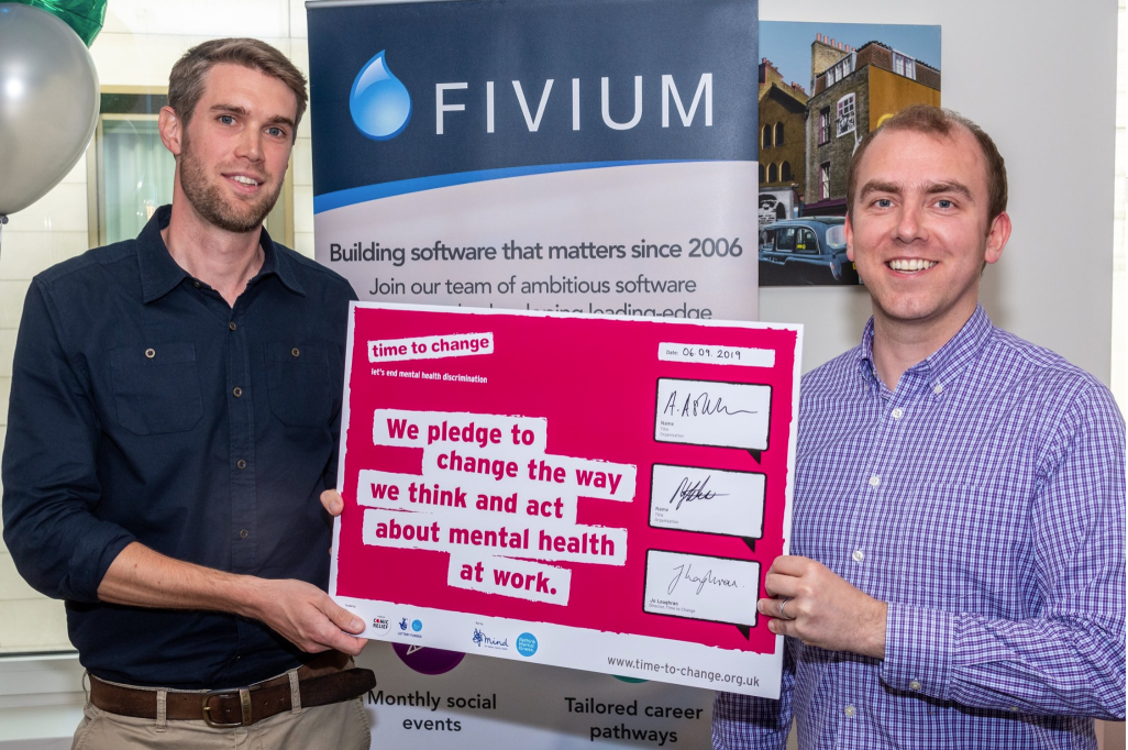 Fivium's directors holding a signed copy of the Time to Change pledge to end mental health discrimination